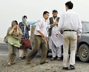 在阿富汗加兹尼省,红十字国际委员会官员协助获救的两名韩国人质离开